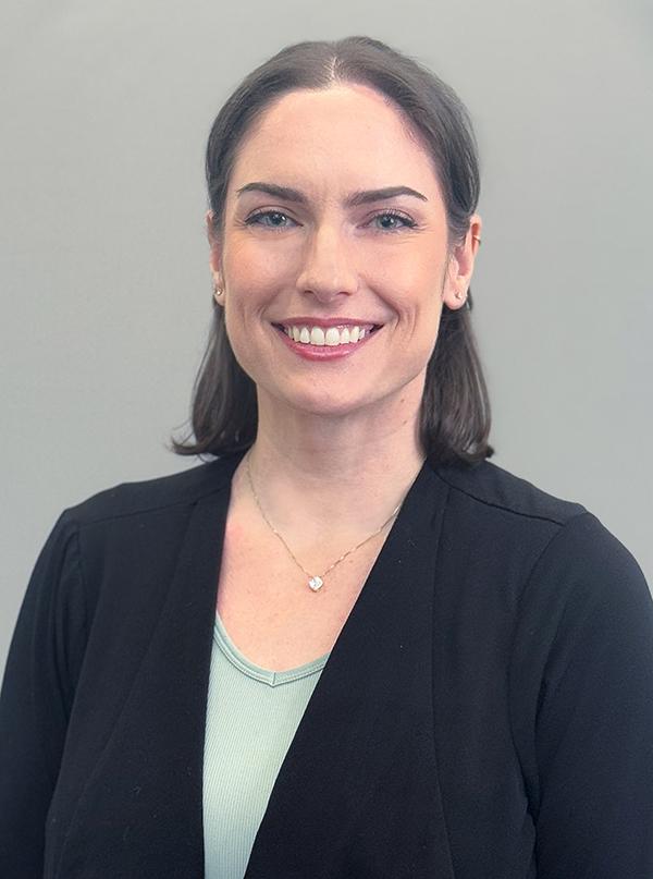 Headshot of attorney Elizabeth Luminoso wearing a black blazer and blue tank. She is smiling.
