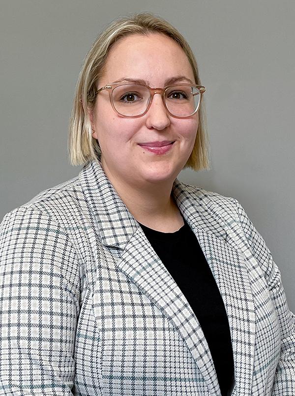 Headshot of attorney Jo Sinta wearing a white and black plaid suit and black blouse.