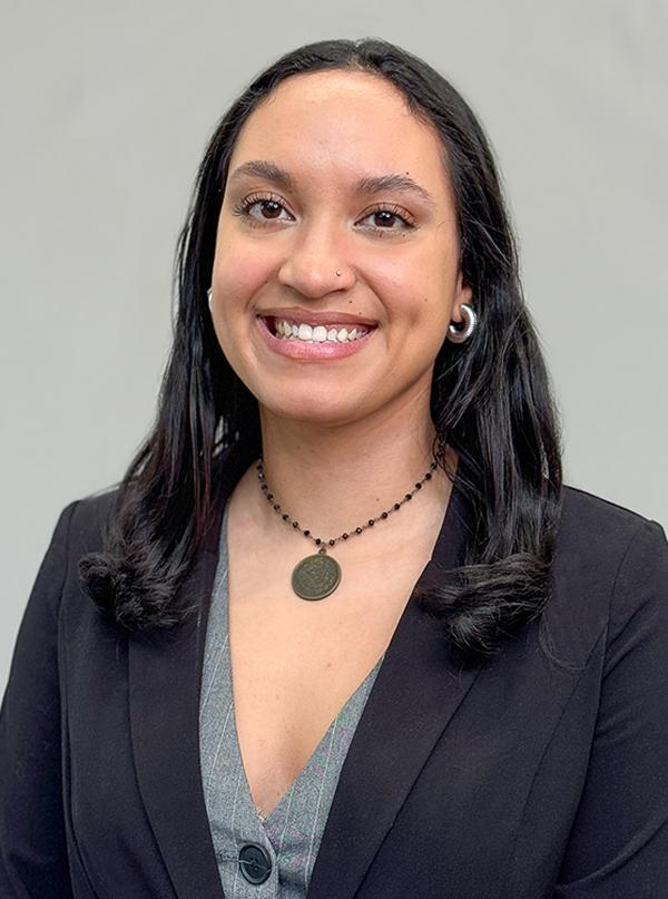Headshot of Krizzia Dejesus wearing a dark suit and v-neck blouse with a necklace.